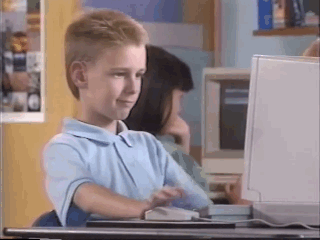 Brent_Rambo A boy sitting in front of a computer giving thumbs up